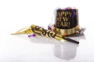 Party favors including top hat that says Happy New Year and horn isolated against white background